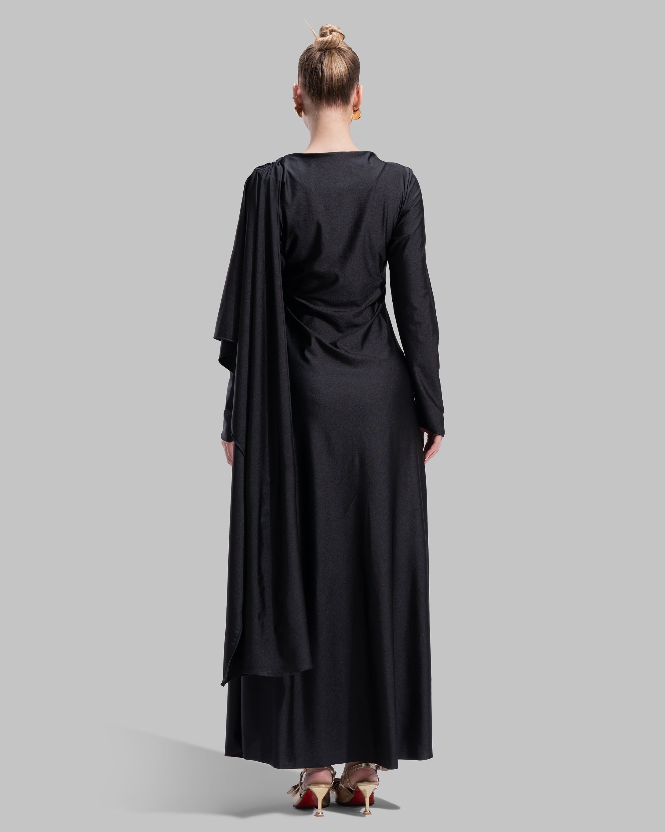 Long draped dress with a round neckline and asymmetrical overlay detail.