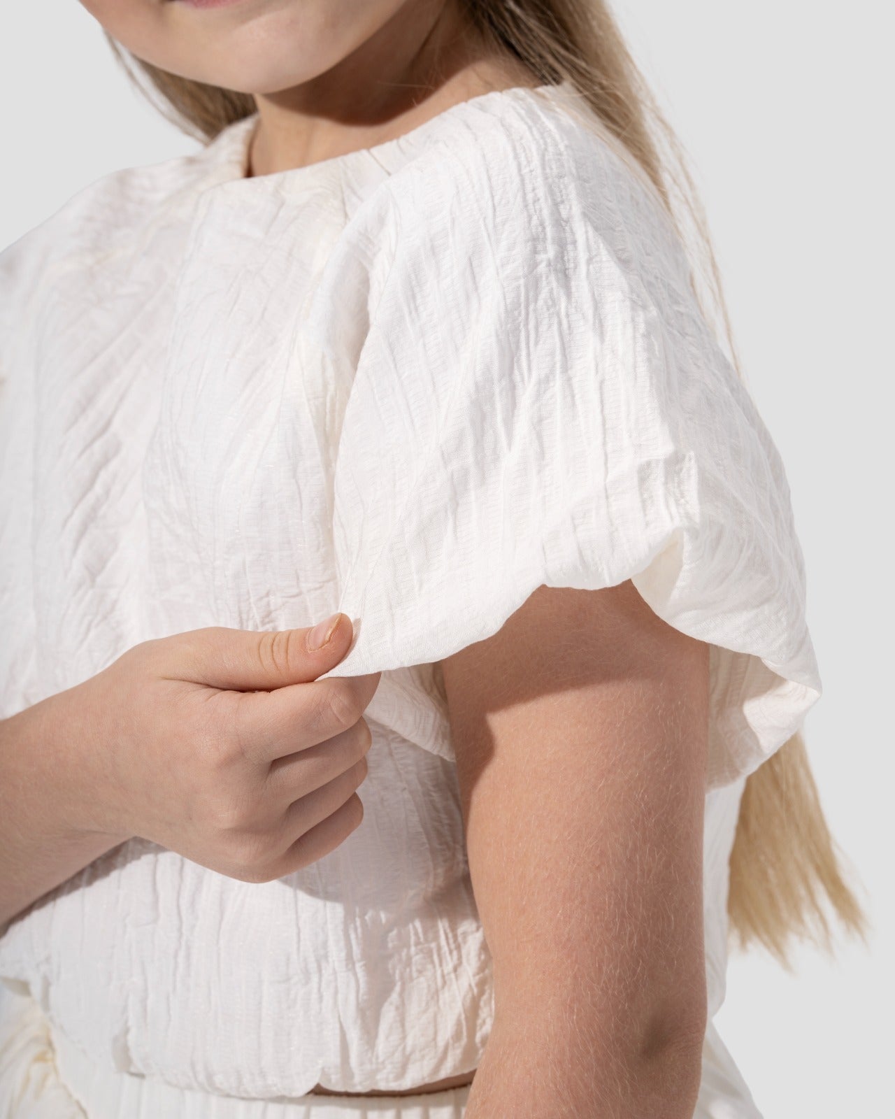 Textured puffy-sleeved top with a round neckline.