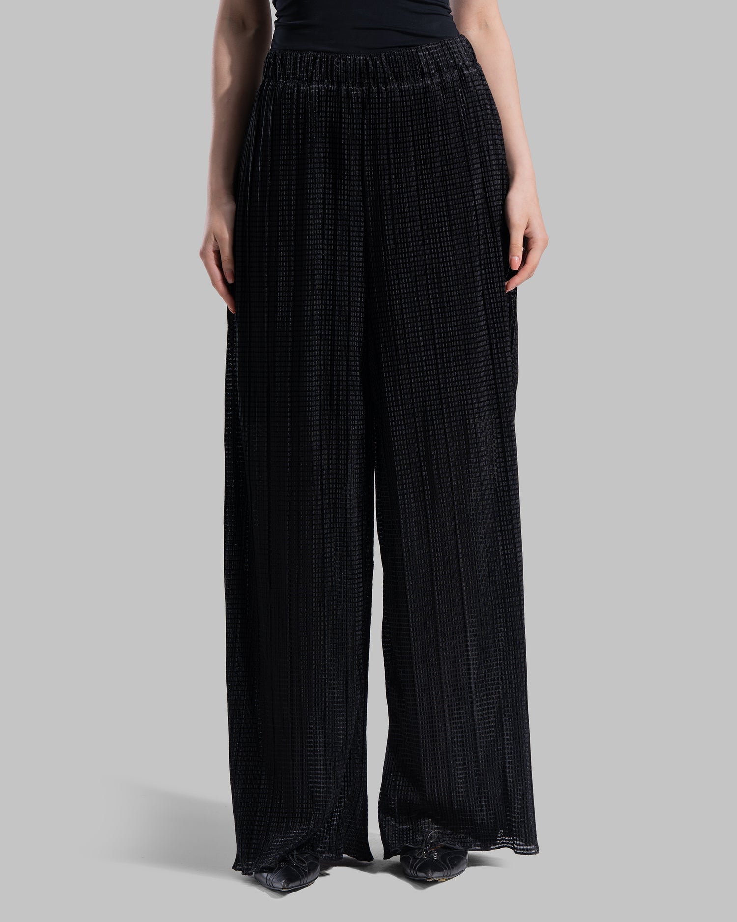 High-waisted wide-leg trousers with an elastic waistband and a textured plissé fabric.