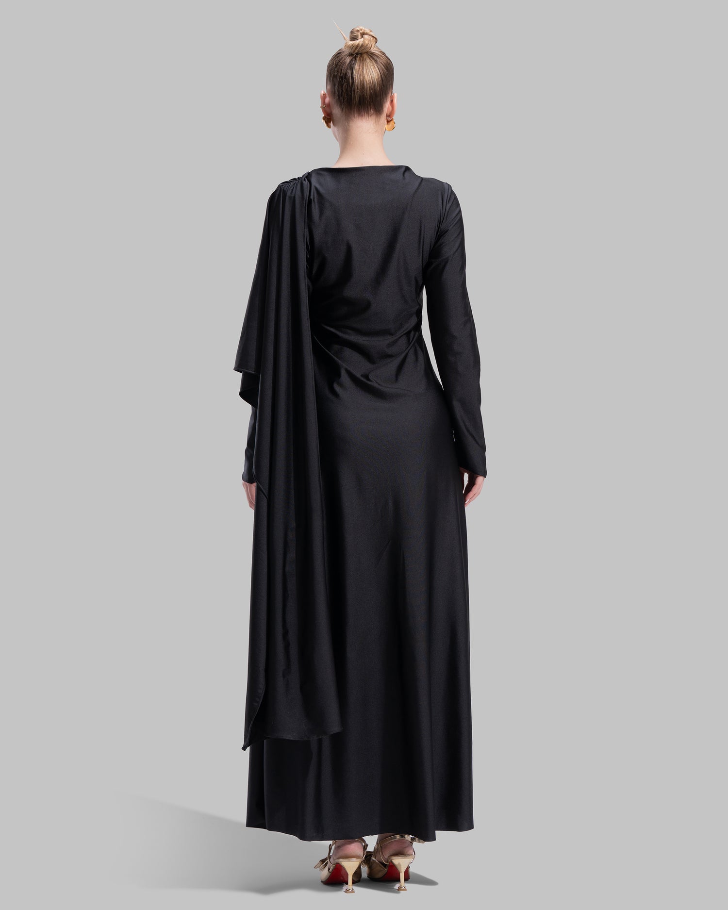 Long draped dress with a round neckline and asymmetrical overlay detail.