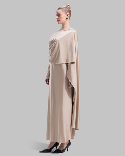 Long draped dress with a round neckline and asymmetrical overlay detail.
