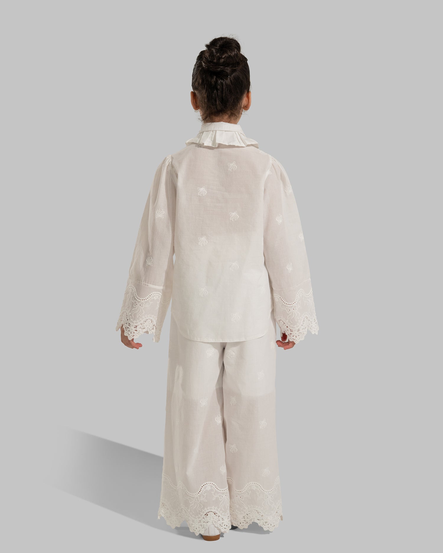 Button-up blouse with a ruffled collar and embroidered lace cuffs.